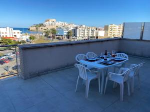 una mesa y sillas en un balcón con vistas en Ático Palacio Inmomart, en Peñíscola