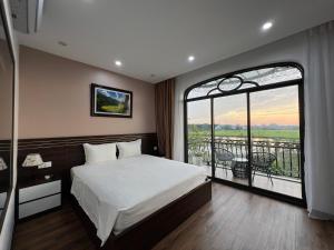 a bedroom with a large bed and a large window at Lotus Hotel Ninh Bình in Ninh Binh