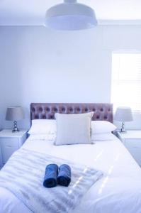 ein Paar blaue Hausschuhe auf einem Bett in der Unterkunft Neat & New Private 2 bedroom Backyard Flat. in Windhoek