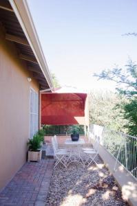a patio with two chairs and a table on a porch at Neat & New Private 2 bedroom Backyard Flat. in Windhoek