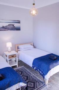 ein Schlafzimmer mit 2 Betten und einem Tisch mit einer Lampe in der Unterkunft Neat & New Private 2 bedroom Backyard Flat. in Windhoek