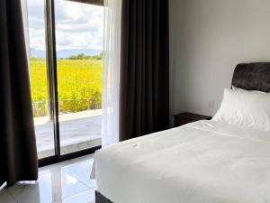 a bedroom with a bed and a window with a view at Paddy Villea with 5 Bedrooms Penang in Permatang Pauh +15 photos