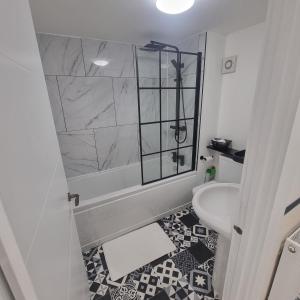 a white bathroom with a shower and a sink at Quite central flat in Plymouth
