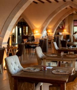 un restaurante con mesas de madera y sillas en una habitación en Hotel Creu de Tau Art&Spa-Adults only en Capdepera