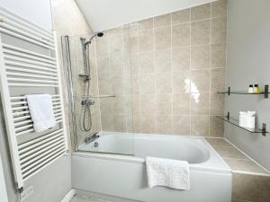 a bathroom with a white tub and a shower at The Warehouse Apartments, 1 - Bed, Sleeps 2, Ulverston - UK in Ulverston +81 photos