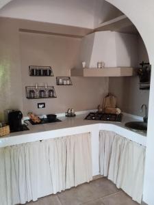 a kitchen with a white counter top with a sink at Dammuso Libeccio in Pantelleria
