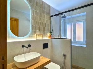 Un baño con un lavabo blanco y un espejo. en Oniria Increíble piso centro Granada, en Granada 44 fotos más