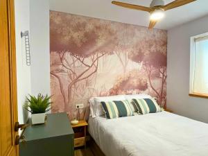 1 dormitorio con 1 cama y un mural en la pared en Home4u Increíble piso centro Granada en Granada