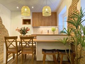 cocina con mesa, sillas y 2 luces en Oniria Increíble piso centro Granada, en Granada