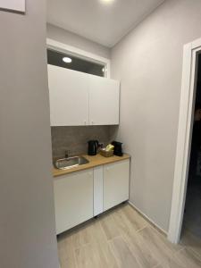 una cocina con armarios blancos y fregadero en La Casa nel Vicolo Camera 3 en Casale Monferrato