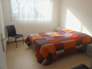 um quarto com uma cama, uma cadeira e uma janela em APPT 2 PIECES 52m² + LOGGIA 7m² REF 4023 em Le Castellas