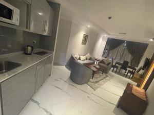 a kitchen and a living room with a couch at Continental Residence in Kuwait