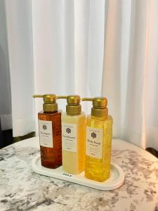 three bottles of honey on a plate on a table at Tokyo Holiday Hotel in Tokyo