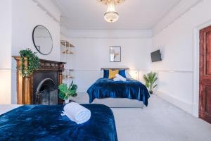 um quarto com 2 camas e uma lareira em Beautiful Pontefract House w/ Parking Sleeps 12 by PureStay em Pontefract
