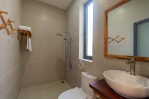 a bathroom with a sink and a toilet and a mirror at Aurora House in Phu Quoc