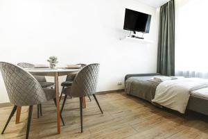 - une chambre avec une table, des chaises et un lit dans l'établissement Wyjątkowe apartamenty w Centrum, à Wrocław