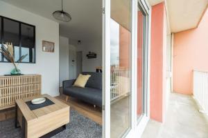 ein Wohnzimmer mit einem Sofa und einem Tisch in der Unterkunft Appartement lumineux avec terrasse Saint-Brieuc in Saint-Brieuc