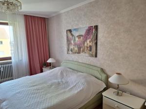 een slaapkamer met een bed en een schilderij aan de muur bij Zimmer mit Sonnenaufgang und ruhiger Innenhof Obergeschoss bei Koberstein in Tutzing