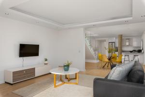un soggiorno con divano, TV e tavolo di Kloof Road Luxury Apartments a Città del Capo