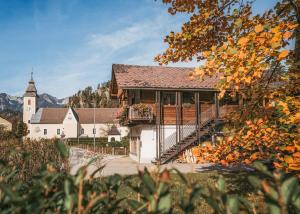 a building with a balcony and a church at NaturparkResort Hobel`s Home in Wildalpen