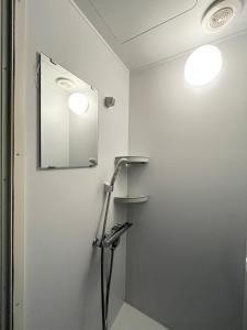 a bathroom with a shower and a mirror at Tokyo Holiday Hotel in Tokyo
