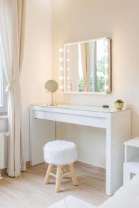 biały toaletka z lustrem i stołkiem w obiekcie Schöne Wohnung mit Terrasse Nähe Airport w Schonefeld