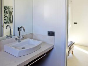 y baño con lavabo blanco y espejo. en Villa De La Brisa - Four Bedroom Villa Sleeps 10 with spectacular sea views en Son Bou