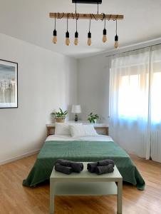 ein Schlafzimmer mit einem großen Bett und einer grünen Decke in der Unterkunft City Apartment Acqui Terme in Acqui Terme