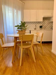 una cucina con tavolo e sedie e una cucina con armadietti bianchi di City Apartment Acqui Terme ad Acqui Terme