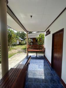 a porch with a bench and a door at Pinks Bungalow in Baan Tai