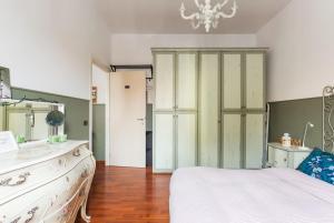 una camera con letto, cassettiera e lampadario a braccio di New Suite Amèlie a Roma