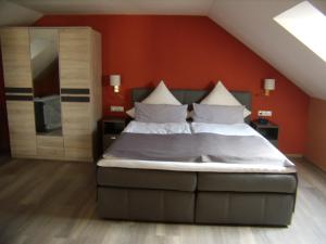 1 dormitorio con 1 cama grande y pared de color naranja en Wellnesshaus Waldmünchen, en Waldmünchen