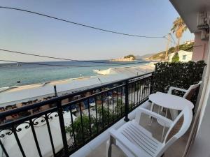 a balcony with two chairs and a view of the ocean at Όμορφο διαμέρισμα με θέα το Αιγαίο in Kokkari