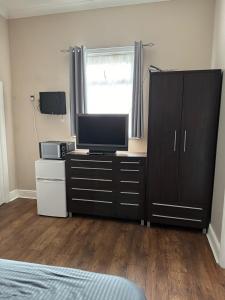 Un dormitorio con un tocador con TV. en Aylesford Guesthouse en Kent