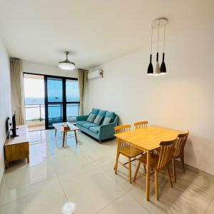 a living room with a table and a blue couch at Seaview 2B1R 5pax Condo Forest City 1G-1608 in Gelang Patah