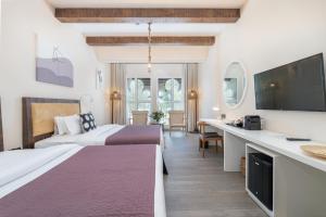 a hotel room with two beds and a flat screen tv at Beach Walk Boutique Jumeirah in Dubai