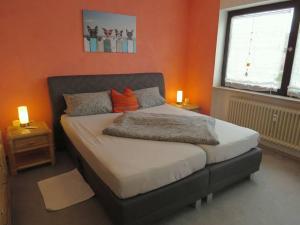 ein Schlafzimmer mit einem Bett mit einer orangefarbenen Wand in der Unterkunft Ferienwohnung Mia in Tirschenreuth