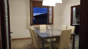 einen Esstisch mit Stühlen und ein Fenster in der Unterkunft Sartinicco Apartment in Montepulciano