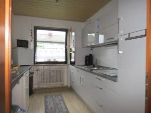 uma cozinha com armários brancos e uma janela em Ferienwohnung Mia em Tirschenreuth