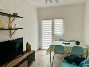 a living room with a table with chairs and a television at Céntrico apartamento bien ubicado para 5, 3 Hab in Alcobendas