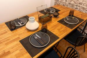 una mesa de madera con platos y utensilios. en Where Dreams Attend Address!, en Atenas