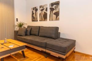 un sofá en una sala de estar con mesa en Where Dreams Attend Address!, en Atenas