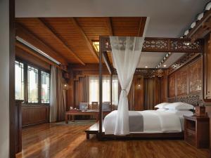 1 dormitorio con 1 cama con dosel en Lee's Boutique Resort en Zhangjiajie