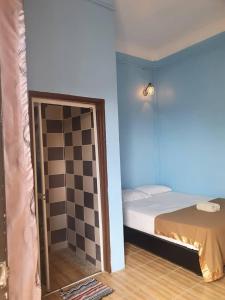 a room with a bed and a checkerboard floor at JV Inn Perhentian in Kampong Pasir Hantu