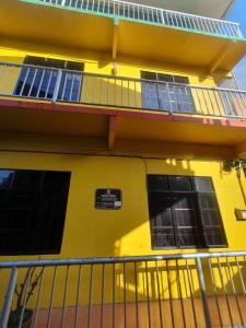 a yellow building with windows and a balcony at JV Inn Perhentian in Kampong Pasir Hantu