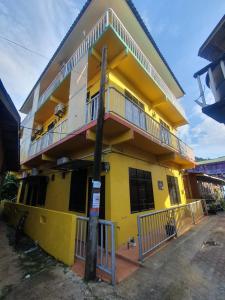 a yellow building with a balcony on top of it at JV Inn Perhentian in Kampong Pasir Hantu