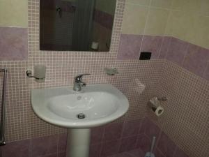 een badkamer met een wastafel en een spiegel bij Mission Relax 1 in Lampedusa