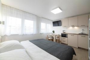 una camera con un grande letto e una cucina di Apartments Pamer, 4th floor a Zagabria