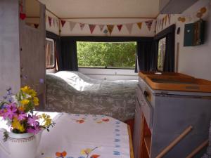einen Wohnwagen mit einer Küche und einem Tisch mit Blumen in der Unterkunft B&B Chambre d'hôtes et Glamping, Bretagne mer et campagne Brittany sea and countryside in Pleumeur-Gautier
