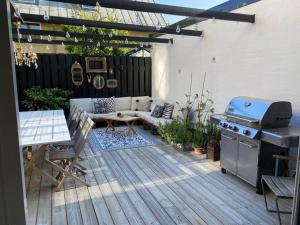 a patio with a couch and a grill and a table at Vackert gathus i Gamla Limhamn nära Eurovision in Malmö